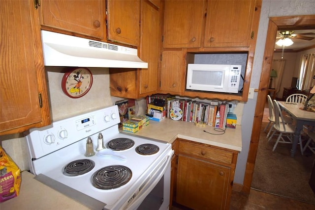 605 SW 6th St, Lindsay, OK 73052 - kitchen with under cabinet range hood, white appliances, and brown cabinetry