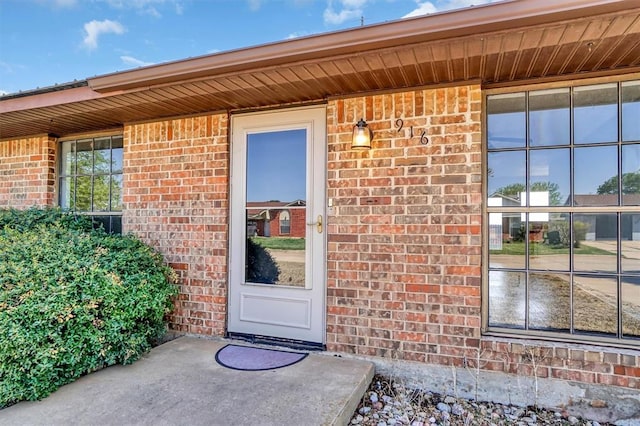 entrance to property featuring brick siding