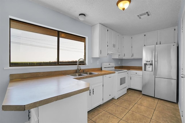 kitchen with white appliances, a textured ceiling, white cabinets, visible vents, and a sink