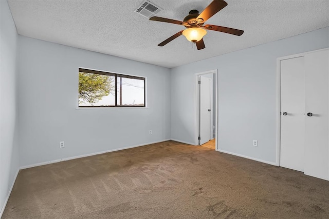 unfurnished bedroom featuring visible vents, a textured ceiling, baseboards, and carpet floors