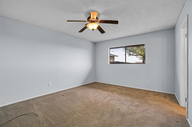 carpeted spare room with a textured ceiling, baseboards, and a ceiling fan