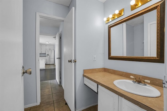 bathroom with tile patterned flooring, vanity, and baseboards