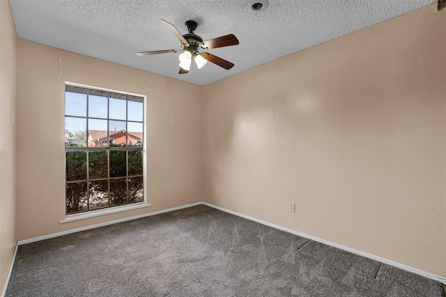 spare room featuring baseboards, a ceiling fan, carpet, and a textured ceiling