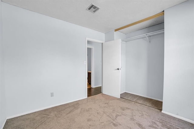 unfurnished bedroom with visible vents, baseboards, a closet, and carpet floors