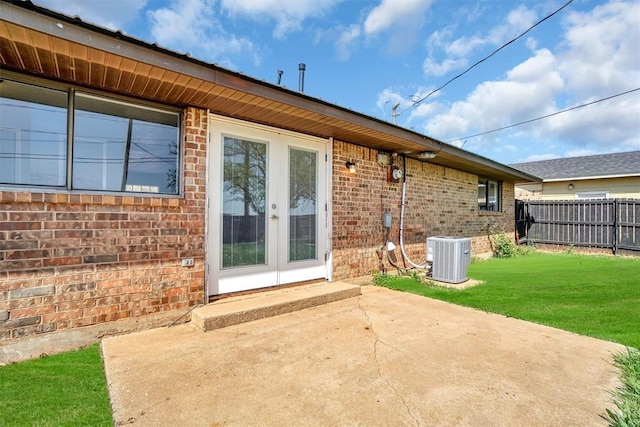 rear view of property featuring brick siding, fence, a patio area, and central AC