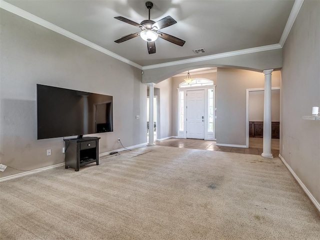 unfurnished living room featuring ceiling fan, carpet floors, arched walkways, decorative columns, and ornamental molding
