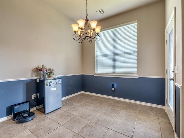 unfurnished dining area with visible vents, baseboards, light tile patterned floors, and a notable chandelier
