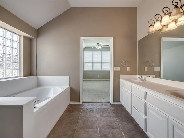 bathroom with double vanity, a garden tub, a sink, baseboards, and lofted ceiling