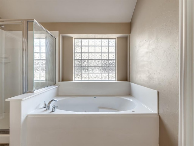 bathroom featuring a shower stall and a bath