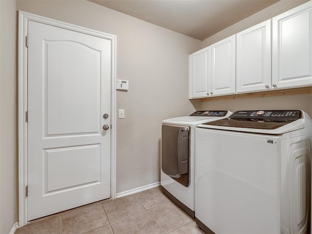 washroom featuring baseboards, cabinet space, independent washer and dryer, and light tile patterned floors