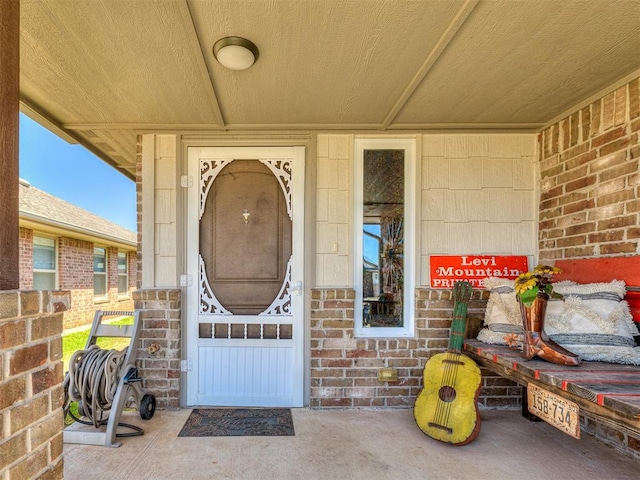 doorway to property featuring brick siding