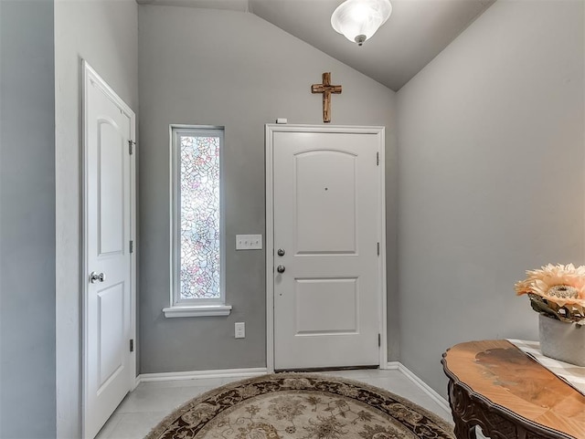 entrance foyer with baseboards, light tile patterned floors, and vaulted ceiling