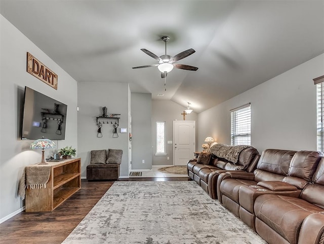 living area featuring ceiling fan, a wealth of natural light, lofted ceiling, and dark wood-type flooring
