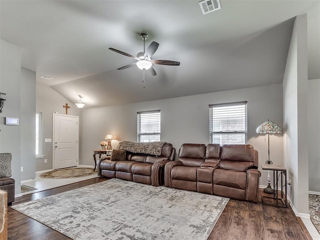 living room with dark wood-style floors, ceiling fan, visible vents, baseboards, and lofted ceiling