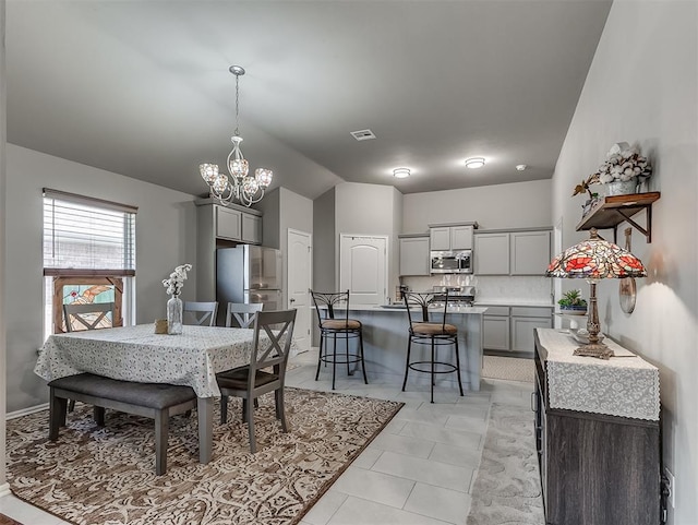 dining room with visible vents, an inviting chandelier, light tile patterned flooring, and lofted ceiling