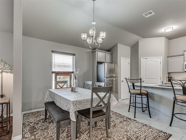 dining area with visible vents, an inviting chandelier, and lofted ceiling
