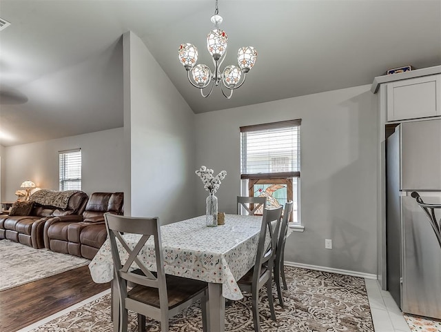 dining area featuring a notable chandelier, baseboards, lofted ceiling, and visible vents