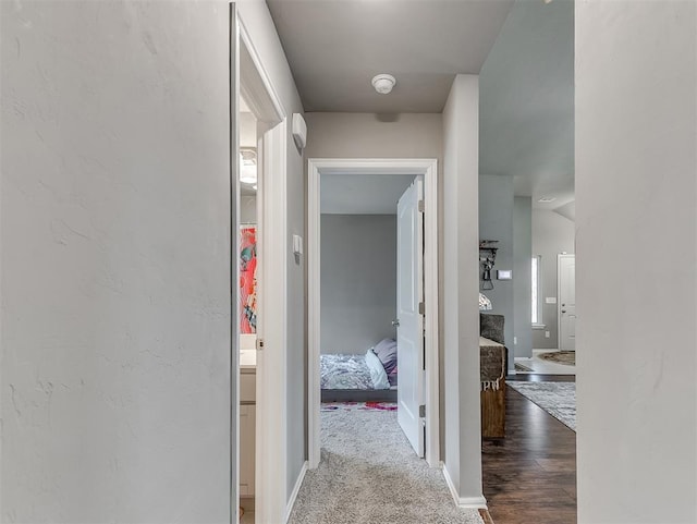 hallway featuring wood finished floors and baseboards