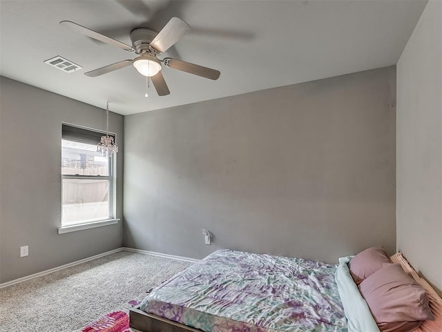 carpeted bedroom with baseboards, visible vents, and ceiling fan with notable chandelier