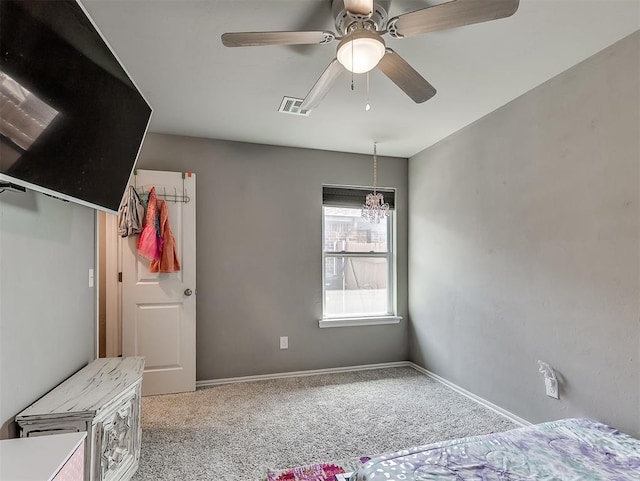 unfurnished bedroom with baseboards, visible vents, ceiling fan with notable chandelier, and carpet floors