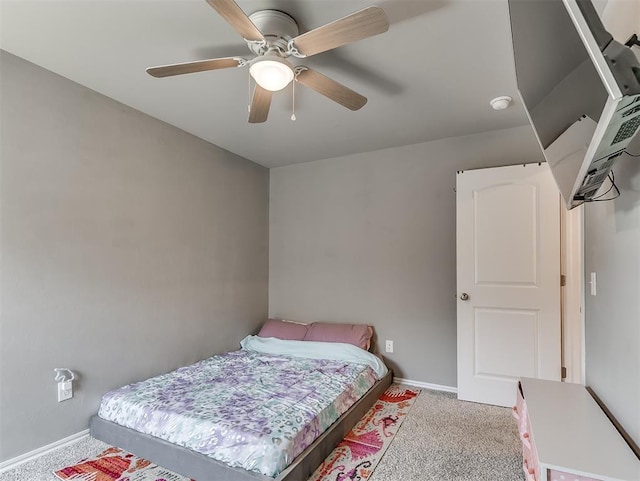 bedroom featuring a ceiling fan, light colored carpet, and baseboards