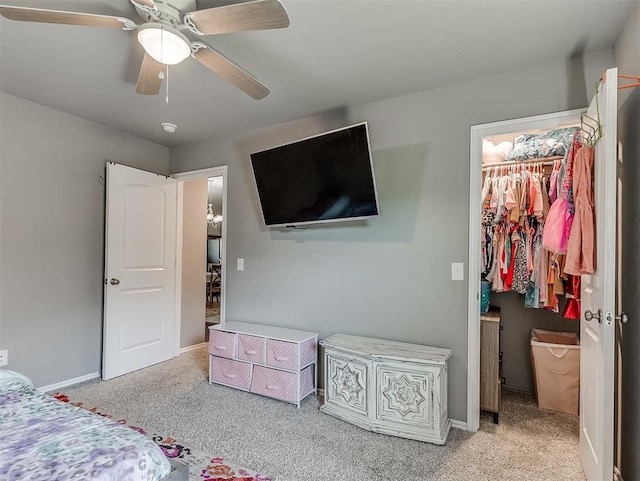 carpeted bedroom with baseboards, a spacious closet, a ceiling fan, and a closet