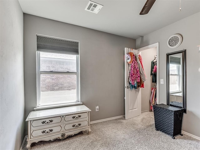 bedroom with multiple windows, ceiling fan, light colored carpet, and visible vents