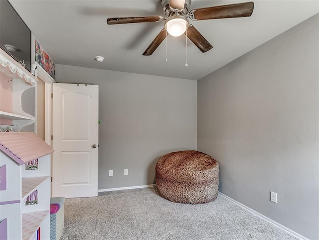 sitting room with carpet, ceiling fan, and baseboards