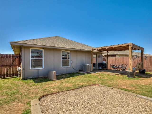 back of property with a fenced backyard, central AC unit, and a yard