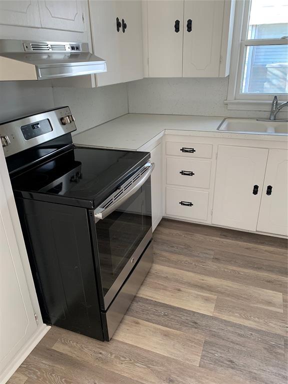1006 N Market St, Shawnee, OK 74801 - kitchen with a sink, white cabinetry, electric stove, and under cabinet range hood
