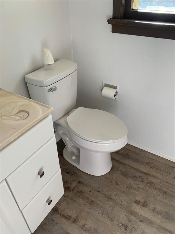 1006 N Market St, Shawnee, OK 74801 - bathroom with toilet, vanity, wood finished floors, and baseboards