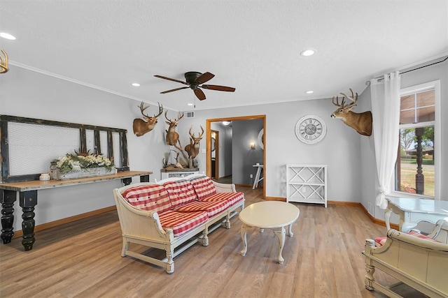 living area with baseboards, ornamental molding, ceiling fan, recessed lighting, and wood finished floors