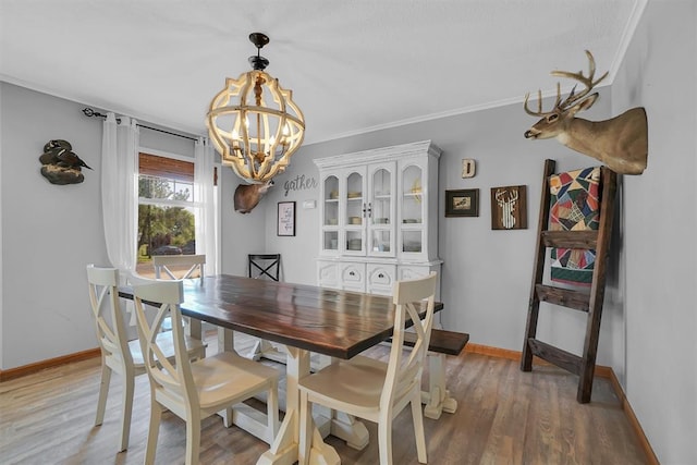 dining area with baseboards, light wood-type flooring, and a notable chandelier