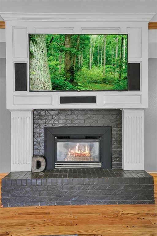 interior details featuring a brick fireplace, baseboards, and wood finished floors