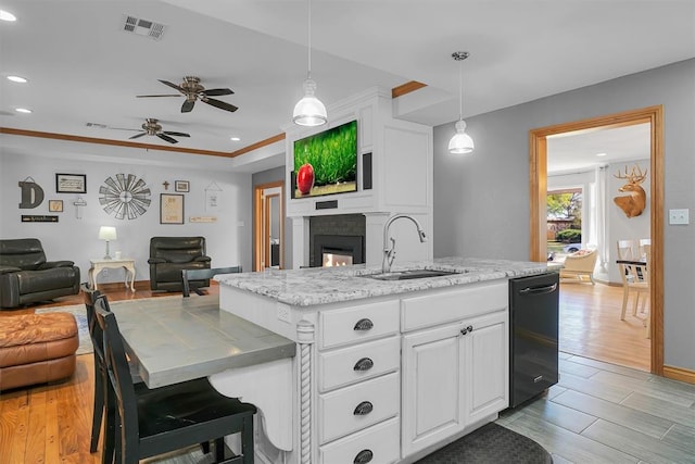 kitchen featuring light wood-style flooring, white cabinetry, visible vents, a sink, and open floor plan