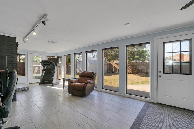 sunroom featuring track lighting, visible vents, and plenty of natural light