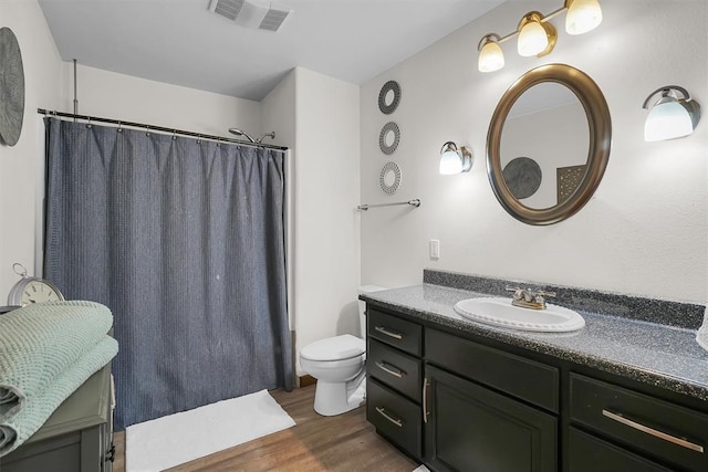 full bathroom featuring visible vents, a shower with curtain, toilet, vanity, and wood finished floors
