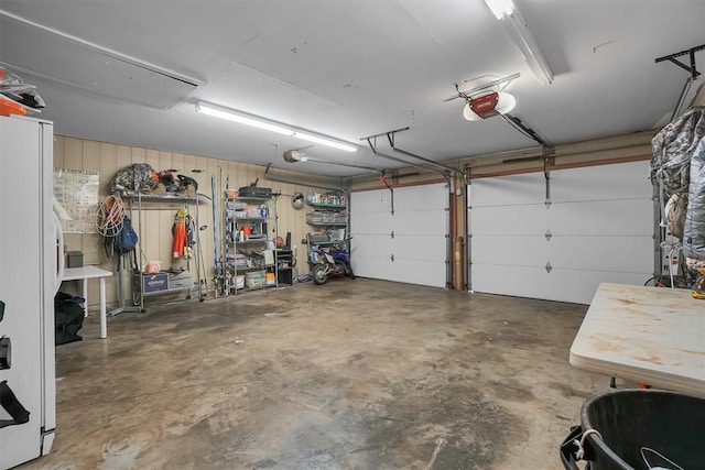 garage with freestanding refrigerator and a garage door opener