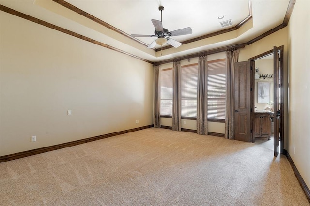 spare room with visible vents, baseboards, a raised ceiling, ceiling fan, and carpet flooring