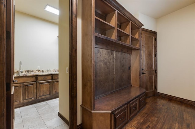 mudroom with a sink and baseboards