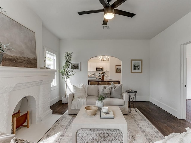 2431 NW 13th St, Oklahoma City, OK 73107 - living area featuring arched walkways, a ceiling fan, wood finished floors, and a chandelier
