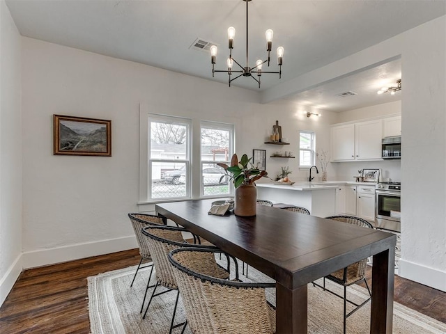 2431 NW 13th St, Oklahoma City, OK 73107 - dining room with dark wood-style floors and a chandelier