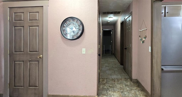 17904 Kings Rd, Shawnee, OK 74801 - hallway with baseboards, stone finish flooring, and a textured wall