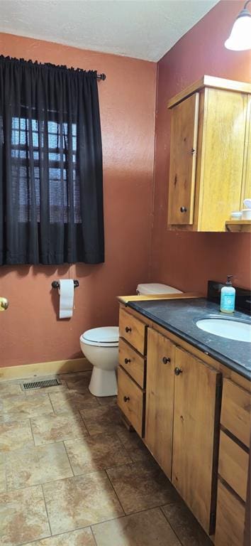 17904 Kings Rd, Shawnee, OK 74801 - bathroom featuring vanity, toilet, stone finish flooring, and baseboards