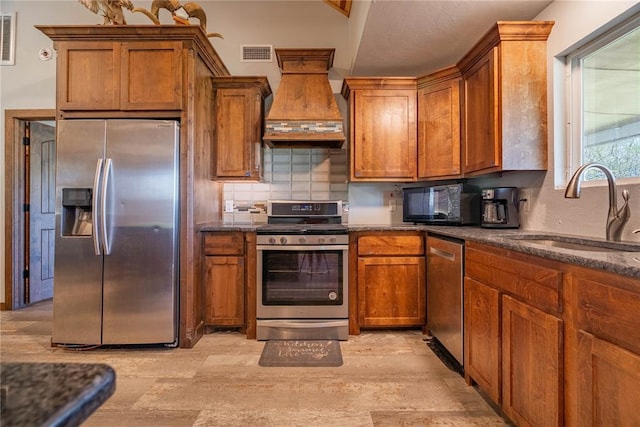 4556 Cobra Ln, Kingston, OK 73439 - kitchen featuring brown cabinetry, visible vents, custom exhaust hood, appliances with stainless steel finishes, and a sink