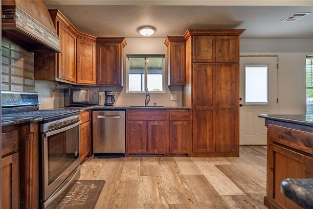 4556 Cobra Ln, Kingston, OK 73439 - kitchen featuring custom range hood, light wood finished floors, visible vents, and appliances with stainless steel finishes