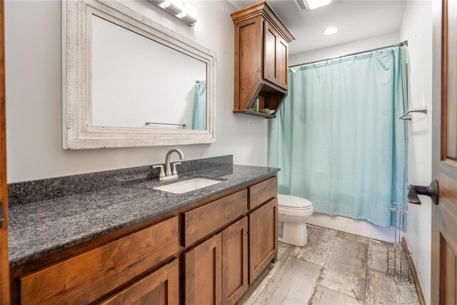 4556 Cobra Ln, Kingston, OK 73439 - full bath with shower / bath combination with curtain, toilet, stone finish floor, recessed lighting, and vanity