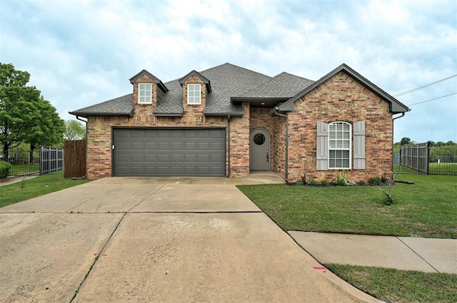 view of front of house with fence, a front yard, brick siding, a shingled roof, and driveway