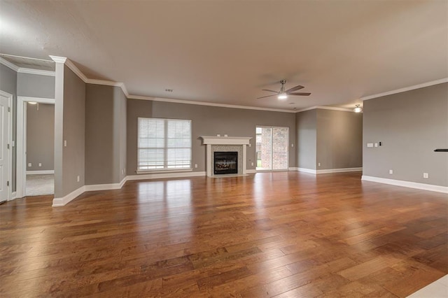unfurnished living room with a ceiling fan, baseboards, wood finished floors, and a fireplace