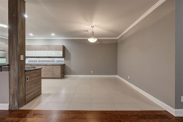 kitchen with visible vents, hanging light fixtures, modern cabinets, baseboards, and ornamental molding